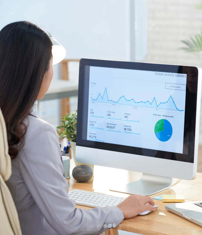 businesswoman studying graphs on desktop